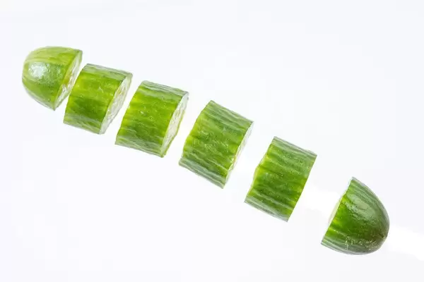 Sliced Mini Cucumber in the air above white background (Flip 2019)