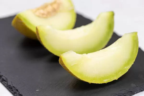 Sliced Mini Melon on the black stone tray