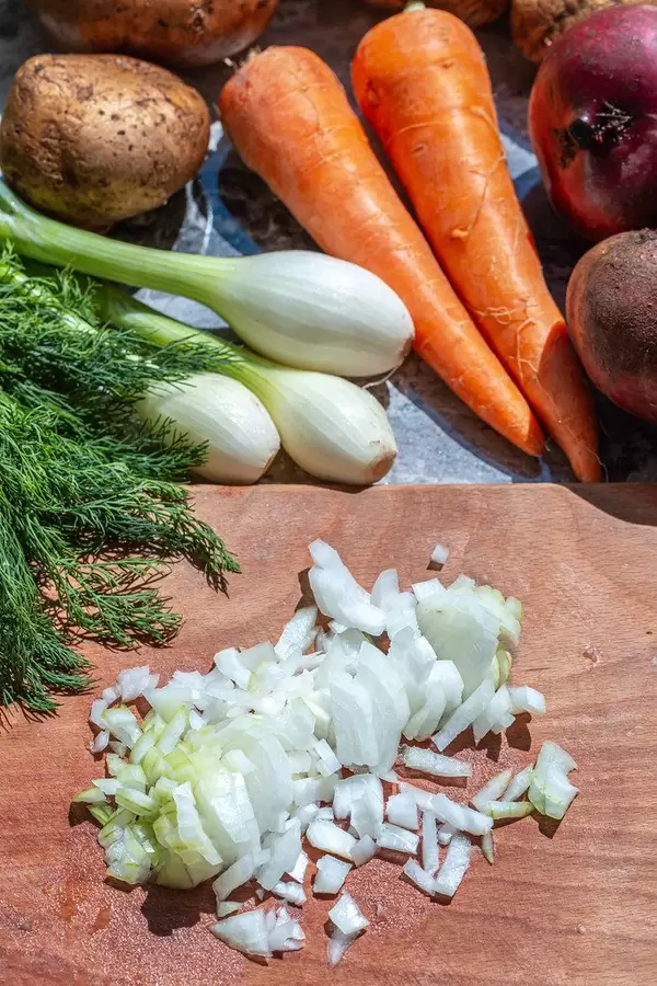 Sliced onion on kitchen Board with vegetables behind