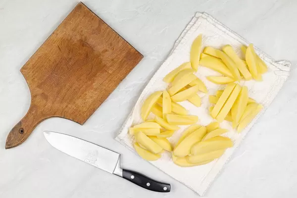 Sliced Potatoes on the kitchen dish towel ready for frying