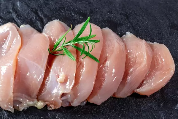 Sliced raw chicken fillet with rosemary