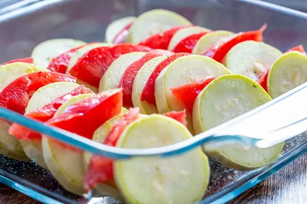 Sliced raw zucchini and tomatoes in a glass pan (Flip 2019) (Flip 2019)