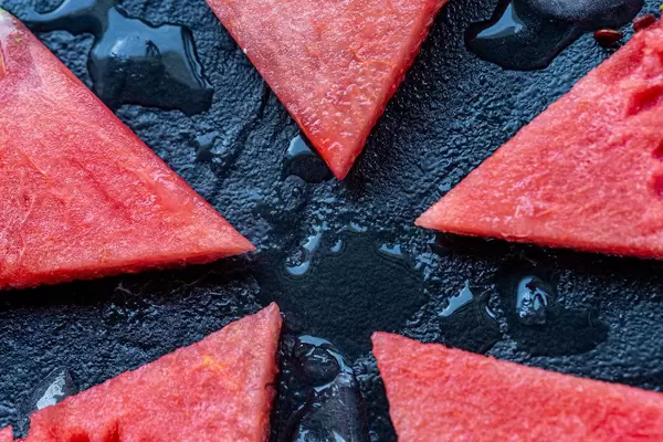 Sliced red sweet watermelon on black stone background (Flip 2019) (Flip 2019)