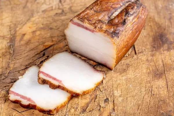 Sliced smoked lard on a wooden background