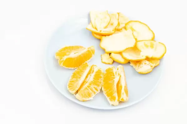 Sliced Tangerine served on the blue plate above white background