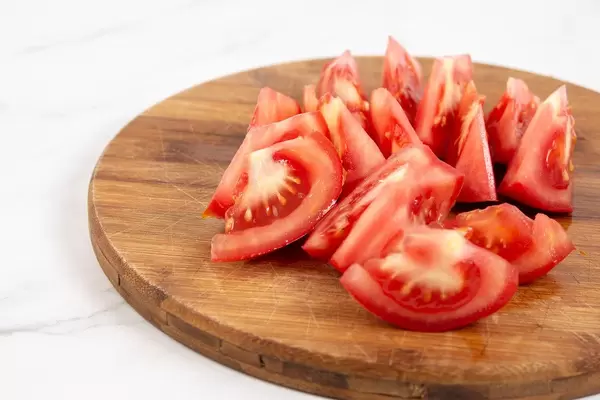 Sliced Tomato on the round cutting board