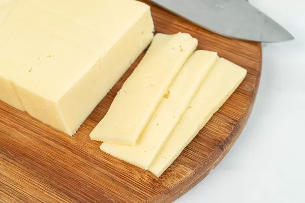Sliced Yellow Cheese on the wooden cutting board (Flip 2019)