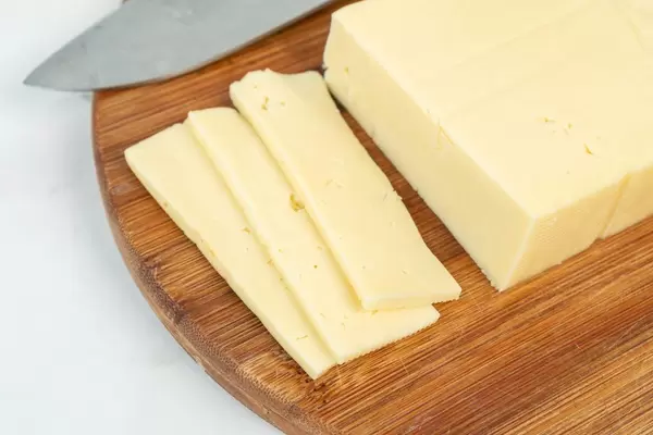 Sliced Yellow Cheese on the wooden cutting board