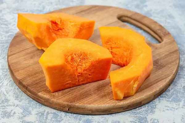 Sliced Yellow Pumpkin on the round wooden board