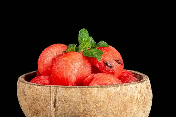 Slices of ripe juicy watermelon with fresh mint on a black background