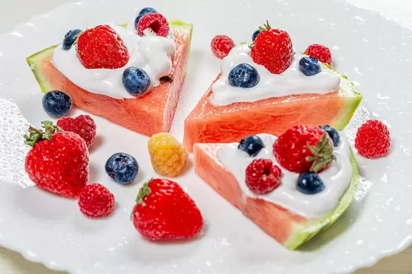 Slices of watermelon with cream and fresh berries on a white plate (Flip 2019)