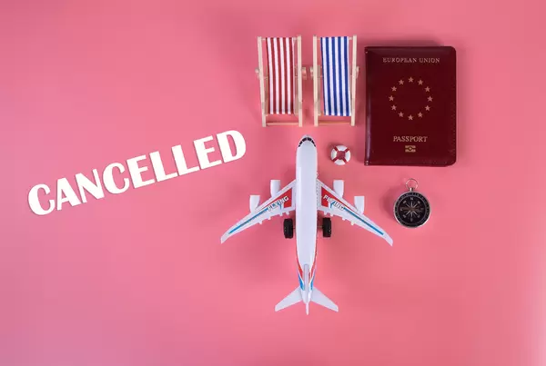 Small airplane with passport, beach chairs and candelled text on pink background