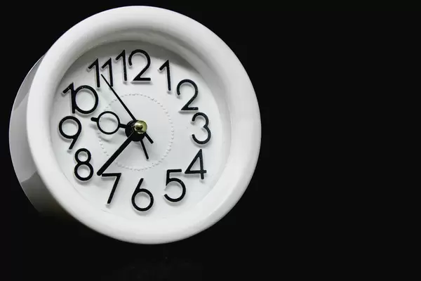 Small alarm clock on black background