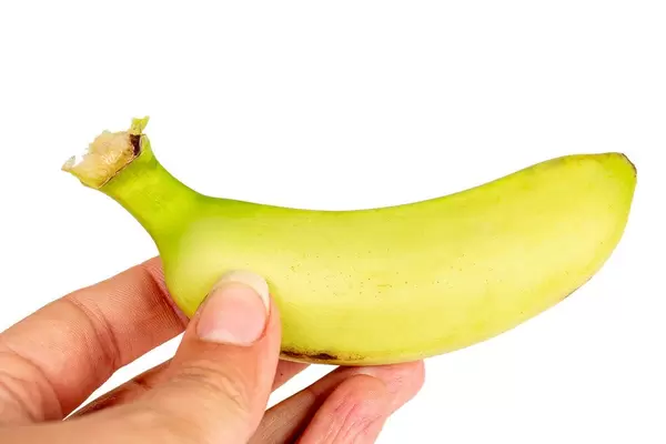 Small fresh banana in a female hand