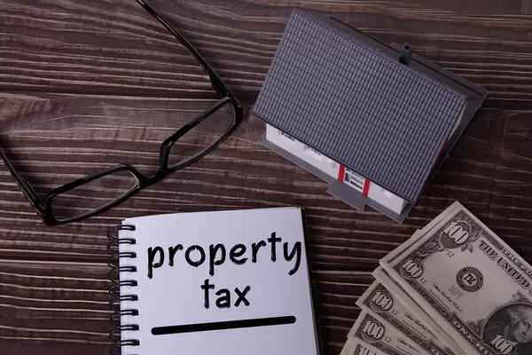 Small house with money and notebook with Property tax text