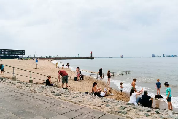 Small patch of crowded public beach next to the empty vast private beach