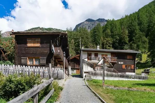 Small path leading to mountains passing through narrow street in a Swiss village of Randa