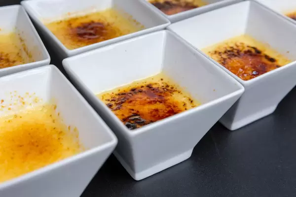 Small portion of creme brulee in a square bowl at a