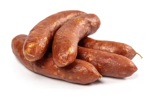 Small smoked sausages on white background