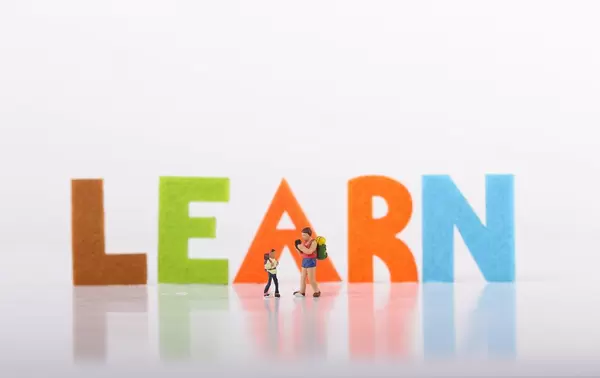 Small traveler figures with Learn text on white background