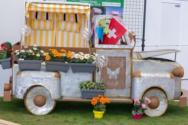 Small van made of sheet with flower pots. Garden decoration