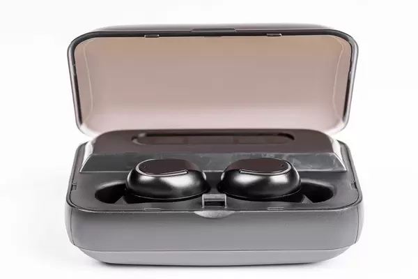 Small wireless headphones in box on white background