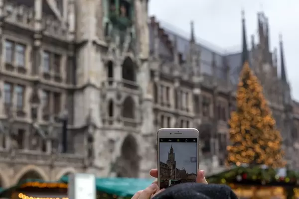 Smartphone fotografiert Kölner Dom mit Weihnachtsmarkt und Weihnachtsbaum
