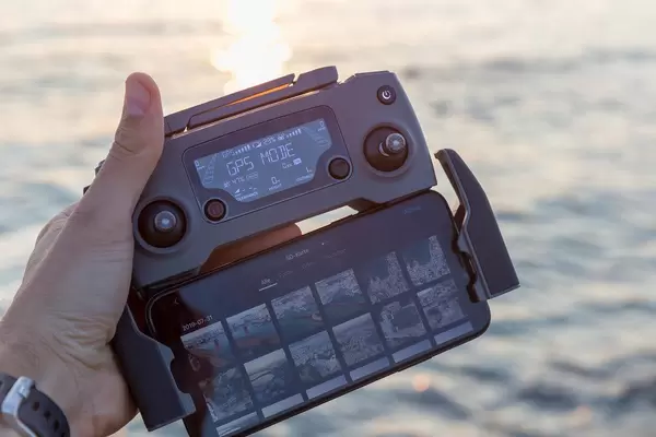 Smartphone mit der DJI Mavic 2 Drohnensteuerung im GPS Mode, vor dem Mittelmeer in Griechenland