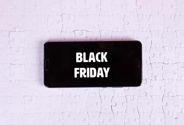 Smartphone on a white jigsaw puzzle with Black Friday text