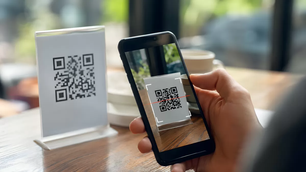 Smartphone scannt QR-Code im Café auf Holztisch