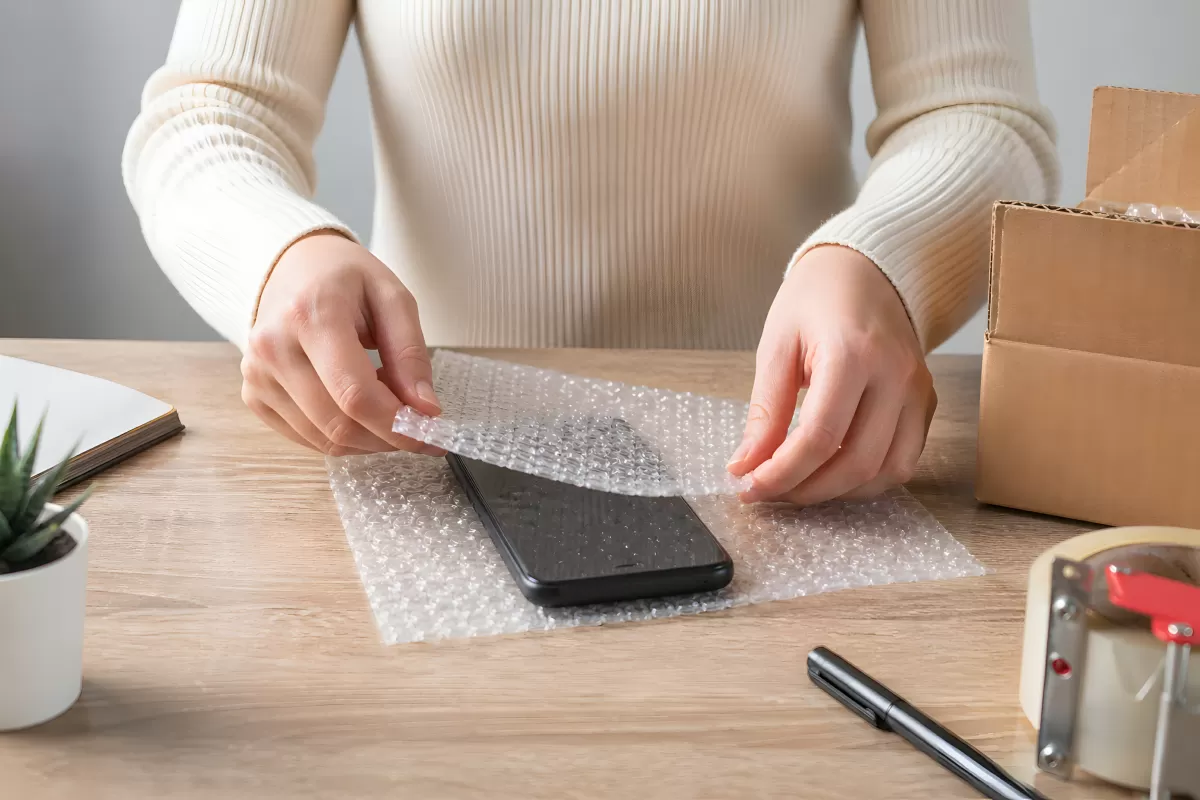 Smartphone wird in Luftpolsterfolie eingepackt