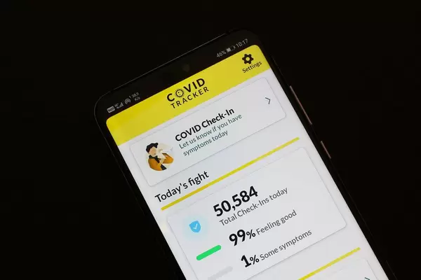 Smartphone with open Covid Tracker app on black background