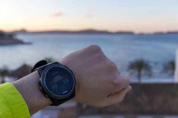 Smartwatch showing sunrise, sea in the backgroung