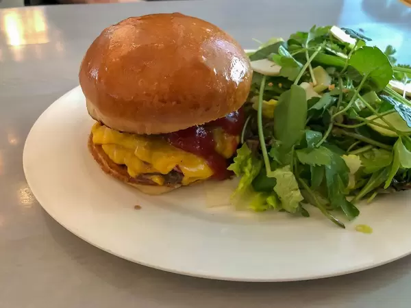 Smash-Bacon Cheeseburger from Pork and Farm To Table salad with organic herbs at cologne Burger Restaurant Karl Hermann's