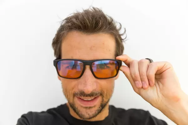 Smiling man satisfied with his gaming glasses by Horus X, for less tired eyes and better enjoyment when playing video games