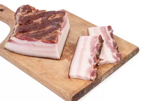 Smoked homemade bacon served on the wooden board (Flip 2019)