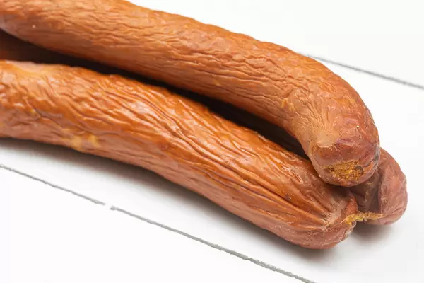 Smoked homemade Sausages on the white wooden table