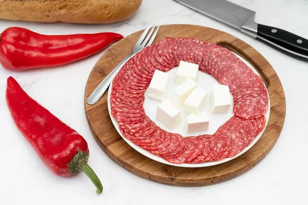 Smoked red Sausage arranged on the plate with Bread and Paprika