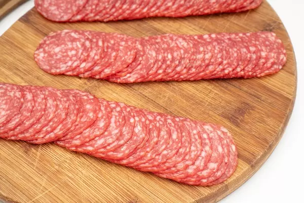 Smoked red Sausage sliced and arranged on the wooden board (Flip 2019)