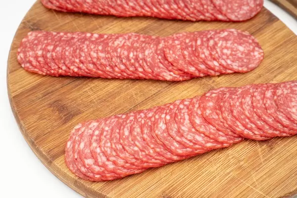 Smoked red Sausage sliced and arranged on the wooden board