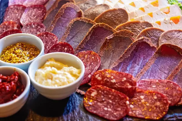 Smoked salami, dried meat and baked fillets with different sauces