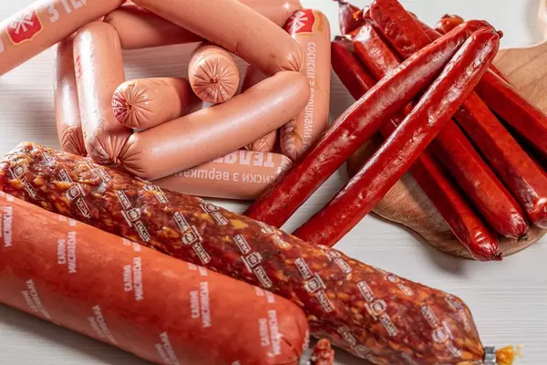 Smoked salami, dried sausage and sausages on table