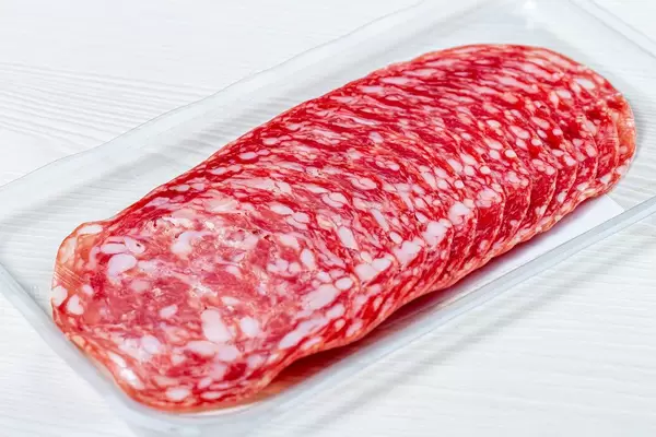 Smoked salami sausages slices on white background (Flip 2019)