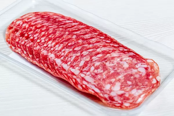 Smoked salami sausages slices on white background