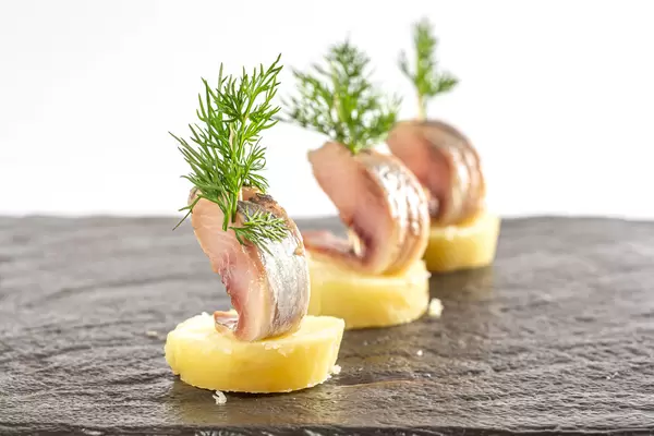 Snack-boats of pickled herring and potatoes