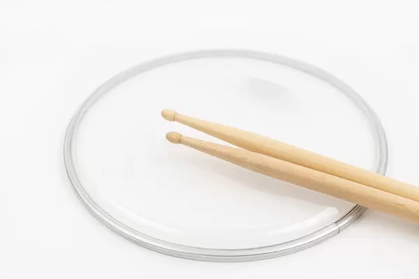 Snare Drum called Butter Head above white background with Drumsticks