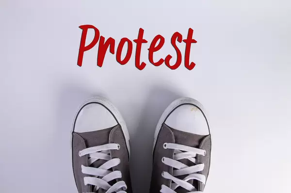 Sneakers and Protest text on white background