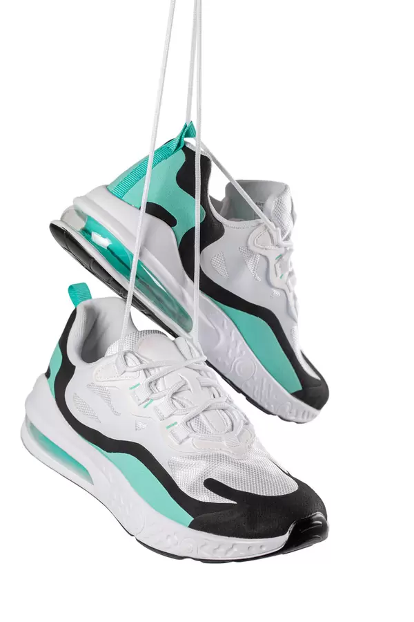 Sneakers hang suspended by their laces