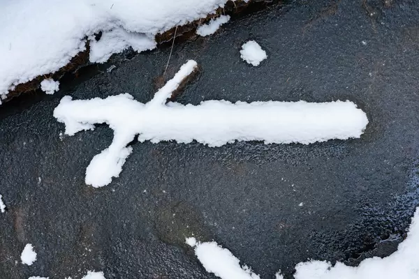 Snow cross left after the tree has melted around it
