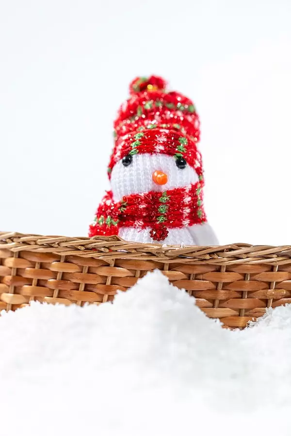 Snowman behind the fence with snow